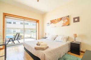 a bedroom with a large bed and a balcony at Oporto city and Beach apartment in Lavra +46 photos