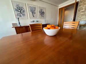un tazón de naranjas sobre una mesa de madera en Playa Malvarrosa House, en Valencia
