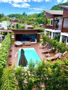- une vue aérienne sur un complexe avec une piscine et des parasols dans l'établissement Pousada Rosa Maria, à Praia do Rosa