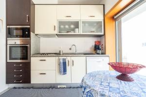 a kitchen with white cabinets and a bowl on a table at Oporto city and Beach apartment in Lavra