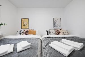 two beds with white towels on them in a room at Venture Vacation - Cozy and Central Apartment in Reykjavík