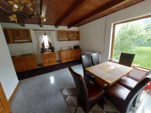 eine Küche mit Tisch und Stühlen und einem Fenster in der Unterkunft Casa Sandu-Sadova in Sadová
