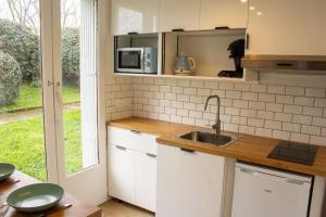 a kitchen with a sink and a microwave at Appartement - terrasse - Cugnaux centre in Cugnaux
