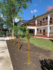 eine Reihe von Giraffenbäumen vor einem Gebäude in der Unterkunft Puszta Hotel in Berekfürdő