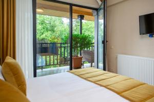 a bedroom with a bed and a view of a balcony at Seventeen Rooms in Tʼelavi