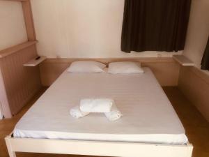 a bed with two white towels on it in a room at Barreira Beachfront Rooms 4 in Kalamata