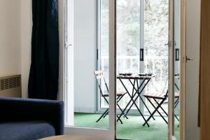 a glass door leading into a room with a table at Studio au calme idéalement situé à Port Olona - La Chaume - 2 personnes in Les Sables-dʼOlonne