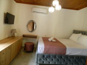 a bedroom with a bed with a mirror and a vanity at Veny House in Paralia Panteleimonos