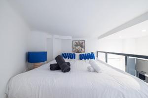 een witte slaapkamer met een groot wit bed met kussens bij SMARTBNB - Moderne Studio - Zone Piétonne - Clim in Nice