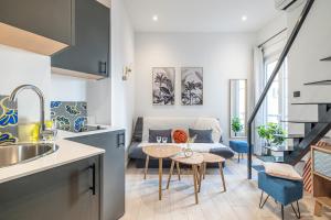 een keuken en een woonkamer met een tafel en een bank bij SMARTBNB - Moderne Studio - Zone Piétonne - Clim in Nice