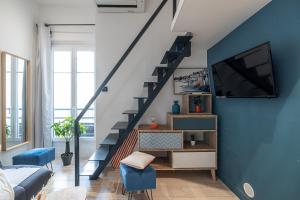 een woonkamer met een blauwe muur en een trap bij SMARTBNB - Moderne Studio - Zone Piétonne - Clim in Nice