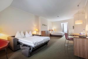 a hotel room with a bed and a table and chairs at Hotel am Jakobsmarkt in Nuremberg