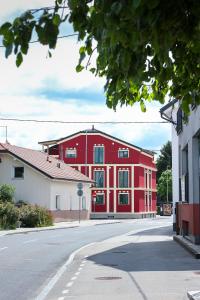 un edificio rojo sentado al lado de una calle en APART HOTEL ASTERIA, en Liubliana