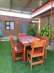 a wooden table and chairs sitting on the grass at Inecia's B & B in Uis