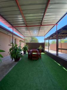 a covered patio with a table and chairs and plants at Inecia's B & B in Uis
