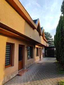 a house with a driveway next to a building at Parrot district apartments in Nové Zámky