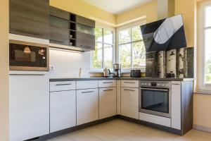 a kitchen with white cabinets and a stove at An den Boddenwiesen 02 in Wieck