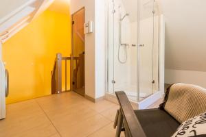 a bathroom with a shower and a chair at An den Boddenwiesen 02 in Wieck +19 photos