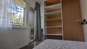 a bedroom with a bed and a window and shelves at Pine forest house 6 in Gauja