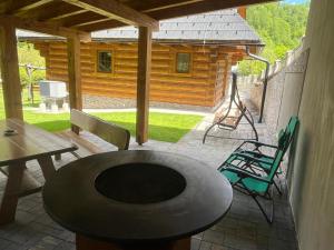 einen Tisch und Stühle auf einer Terrasse mit einer Hütte in der Unterkunft Chata Sipkova II in Terchová