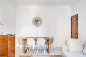 a dining room with a table and chairs and a couch at Hopstays - Almada Saudade in Almada +8 photos