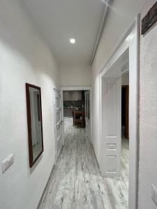 Un pasillo vacío con paredes blancas y pisos de madera. en Lia House, en Brasov