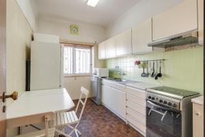 a kitchen with white cabinets and a stove top oven at Hopstays - Almada Saudade in Almada