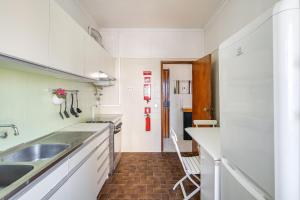 a white kitchen with a sink and a counter at Hopstays - Almada Saudade in Almada