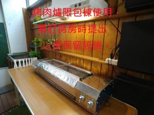einem Grill, der auf einem Tisch sitzt und an der Wand schreibt in der Unterkunft 木Box田妍山色 in Jiaoxi