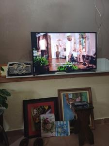 a flat screen tv sitting on a shelf with pictures at Rancho Meu Ambiente in Águas de Lindóia