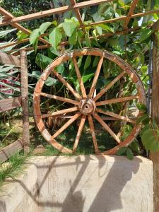 an old wooden wagon wheel sitting on the grass at Rancho Meu Ambiente in Águas de Lindóia
