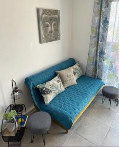 a blue couch in a living room with two chairs at Romytt Suite in Saint-Quentin-la-Poterie