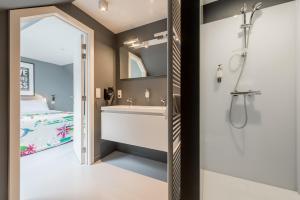 een badkamer met een wastafel, een douche en een bed bij Smartflats Design - Postiers in Brussel