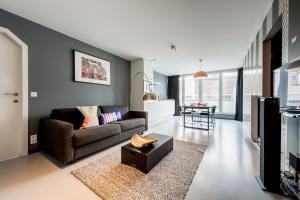 een woonkamer met een bank en een tafel bij Smartflats Design - Postiers in Brussel