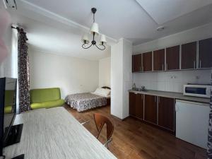 Apart hotel Asotel في خاركوف: مطبخ وغرفة معيشة مع طاولة وسرير