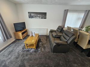 uma sala de estar com um sofá e uma televisão em Modern Spacious walking distance to castle & town em Abergele