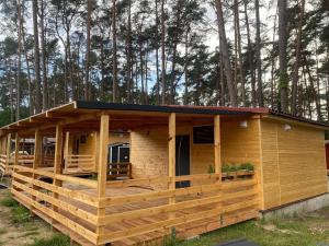 a house with a large deck in the woods at Oto Domek 2 in Międzyrzecz +11 photos