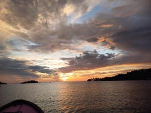 a view of a sunset from a boat on a body of water at Cabaña La Punta in Isla Grande