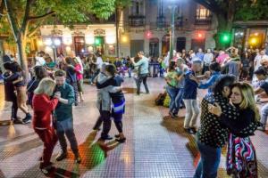 a crowd of people dancing on a street at night at En el corazón de San Telmo in Buenos Aires