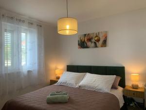 a bedroom with a large bed with a green headboard at Apartments Panda in Bol