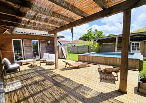 a wooden deck with a swimming pool in a backyard at Spacieuse maison avec piscine, 9km de l'océan. in Tosse