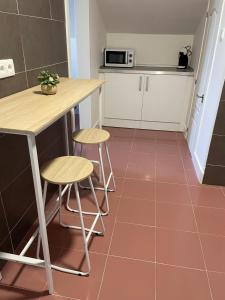 a kitchen with a counter and two stools and a table at Apartamento en Covas in Ferrol
