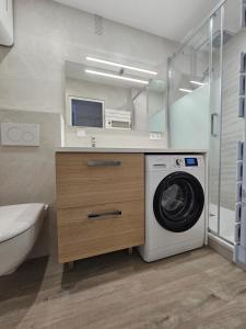 een badkamer met een wasmachine en een wastafel bij Le Capitole - Studio Plage Benoit - Escapade Hivernale in La Baule