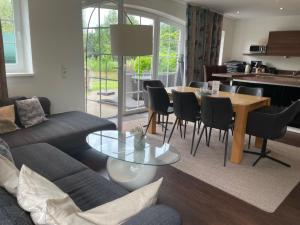 a living room with a couch and a table and chairs at Huus an't Gracht in Greetsiel