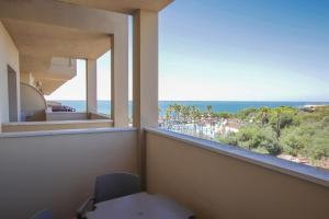 um quarto com uma janela com vista para o oceano em Ohtels Mazagon em Mazagón