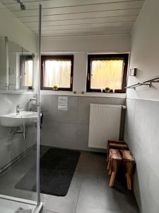 a bathroom with a sink and a shower and a bench at Landhaus Stetten in Stetten