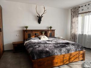 a bedroom with a bed with a deer head on the wall at Landhaus Stetten in Stetten