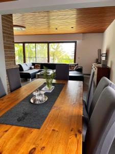 a dining room with a wooden table and a living room at Landhaus Stetten in Stetten