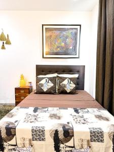 1 dormitorio con 1 cama y una pintura en la pared en Résidence Théa, en Dakar