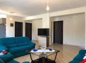 a living room with a blue couch and a table at Eleni house near Asprovalta Ν2 in Néa Kerdhília